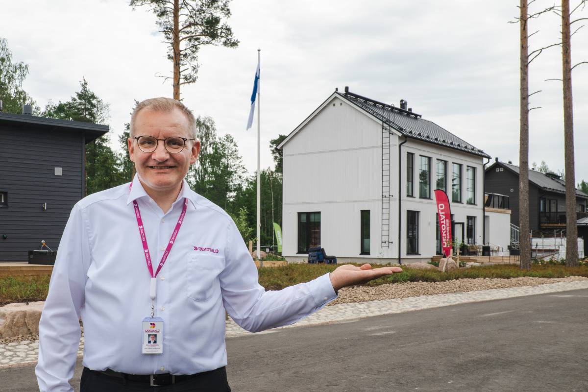Dekotalon myyntijohtaja Mika Issakainen pitää Loviisan asuntomessutalo Lilla Hyggea "kädellään" eli osoittaa valmistaloa, joka oli asuntomessuilla esittelyssä.